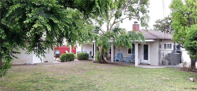 back of property featuring stucco siding, central AC unit, and a chimney