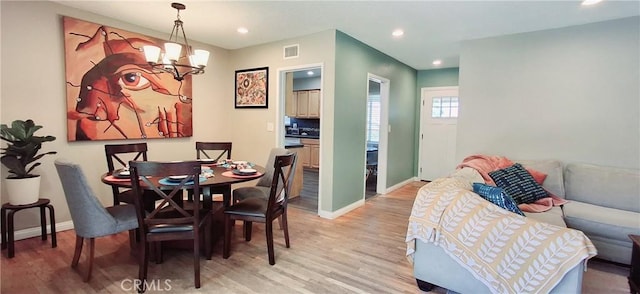 dining area with light wood-style flooring, a chandelier, baseboards, and recessed lighting