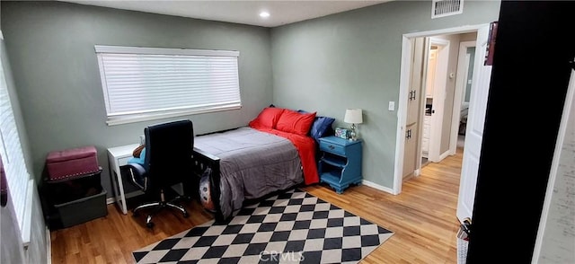 bedroom featuring light wood finished floors, baseboards, and recessed lighting