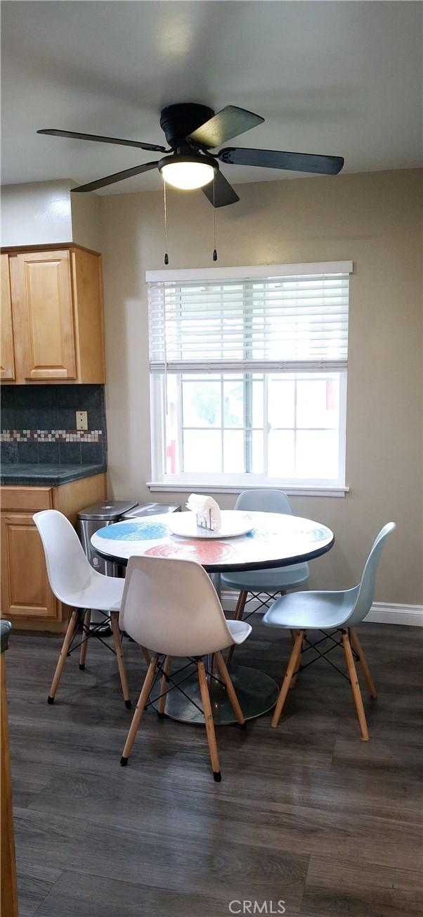 dining room with plenty of natural light, ceiling fan, and dark wood finished floors