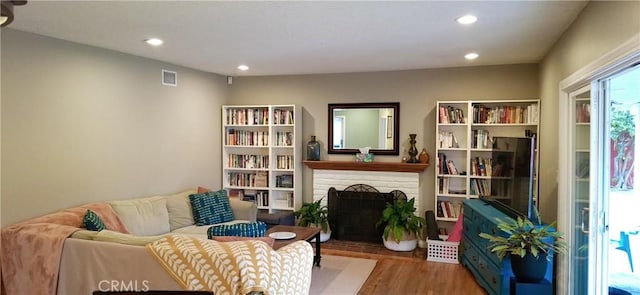 sitting room featuring wood finished floors, recessed lighting, and a fireplace