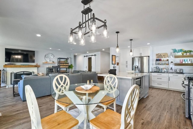 2760 Thunder Dr, Oceanside, CA 92056 - dining area with a barn door, wood finished floors, recessed lighting, and a fireplace