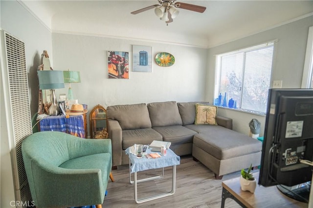 living area featuring crown molding, a ceiling fan, wood finished floors, and a heating unit