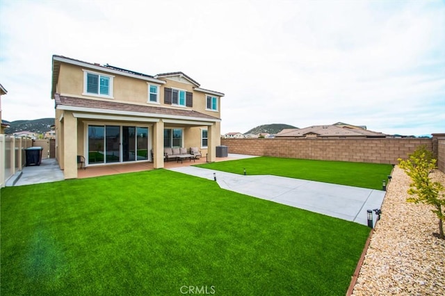 rear view of house featuring a patio, a fenced backyard, and stucco siding