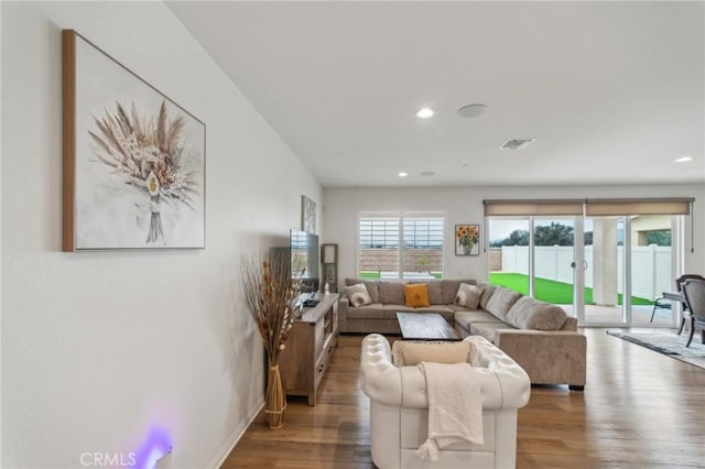 living area featuring visible vents, baseboards, recessed lighting, and wood finished floors