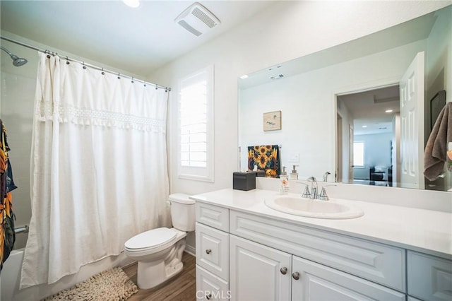 bathroom featuring visible vents, toilet, vanity, and a healthy amount of sunlight