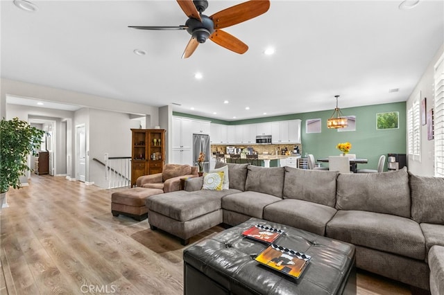 23757 Cahuilla Ct, Corona, CA 92883 - living room with light wood finished floors, a chandelier, recessed lighting, and ceiling fan