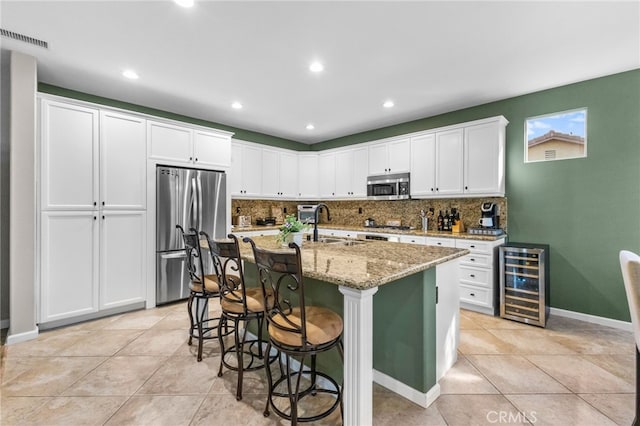 kitchen featuring visible vents, wine cooler, tasteful backsplash, and stainless steel appliances
