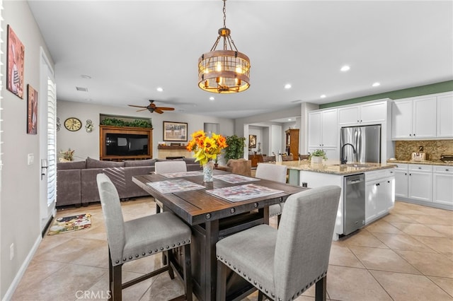 dining space with light tile patterned flooring, recessed lighting, ceiling fan with notable chandelier, and visible vents