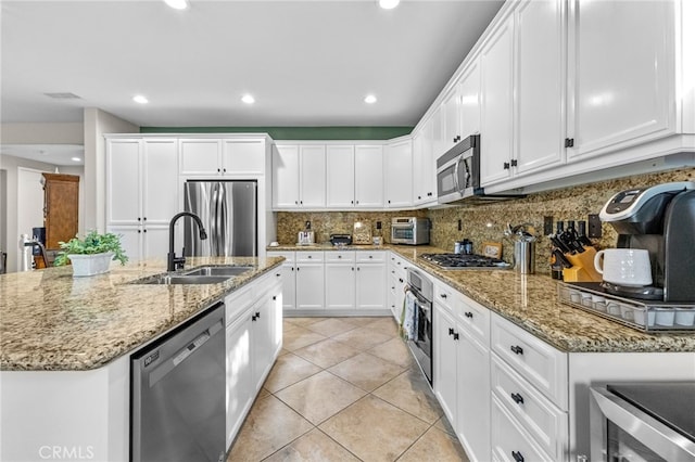 23757 Cahuilla Ct, Corona, CA 92883 - kitchen featuring stainless steel appliances, a sink, white cabinets, decorative backsplash, and light tile patterned flooring