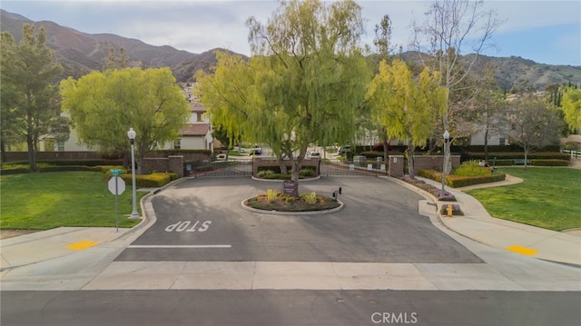 23757 Cahuilla Ct, Corona, CA 92883 - view of property's community featuring a mountain view, a gate, a lawn, and uncovered parking