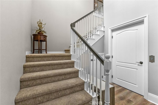 stairway featuring baseboards and wood finished floors