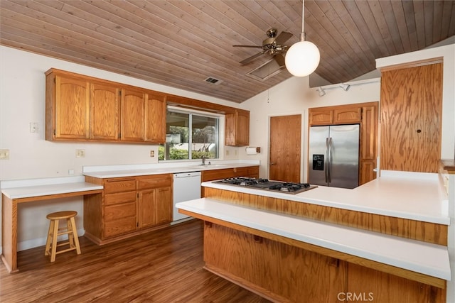 51674 Rd 426, Oakhurst, CA 93644 - kitchen with dark wood-style flooring, a peninsula, stainless steel appliances, and brown cabinetry