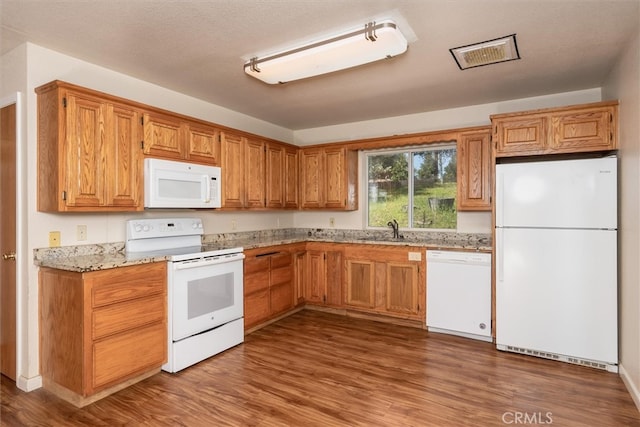 51674 Rd 426, Oakhurst, CA 93644 - kitchen with light stone counters, a sink, wood finished floors, brown cabinetry, and white appliances
