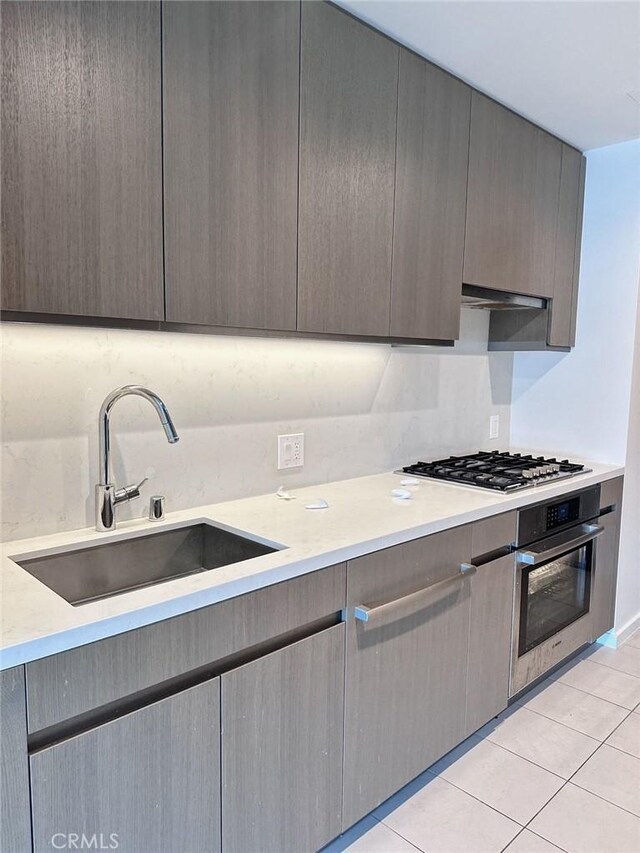 889 Francisco St Unit 2505, Los Angeles, CA 90017 - kitchen featuring stainless steel appliances, a sink, light countertops, and light tile patterned floors