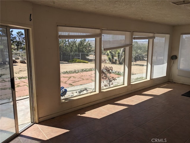 8802 Rubidoux Ave, Yucca Valley, CA 92284 - unfurnished sunroom featuring a textured ceiling and tile patterned floors