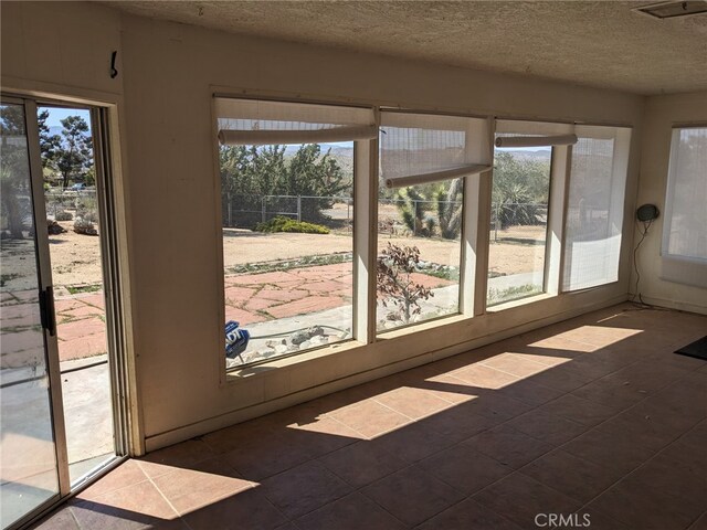 8802 Rubidoux Ave, Yucca Valley, CA 92284 - unfurnished sunroom with a textured ceiling and tile patterned flooring