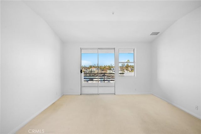unfurnished room featuring visible vents, baseboards, and light colored carpet