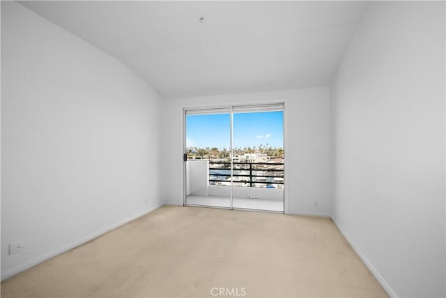 spare room with baseboards, vaulted ceiling, and carpet flooring