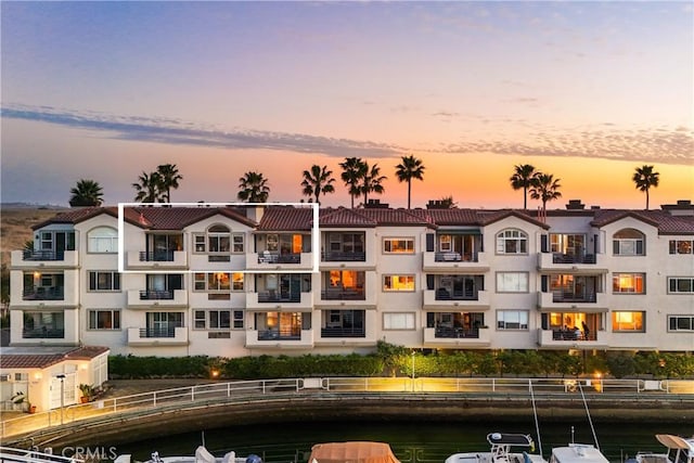 property at dusk with a water view