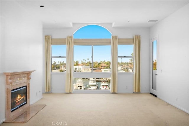 unfurnished living room featuring a fireplace, baseboards, and carpet