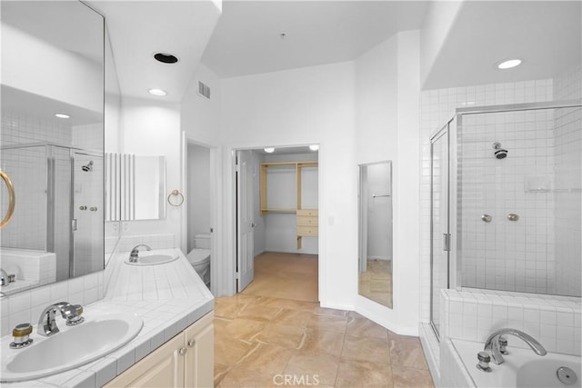 bathroom featuring visible vents, toilet, vanity, a garden tub, and a stall shower