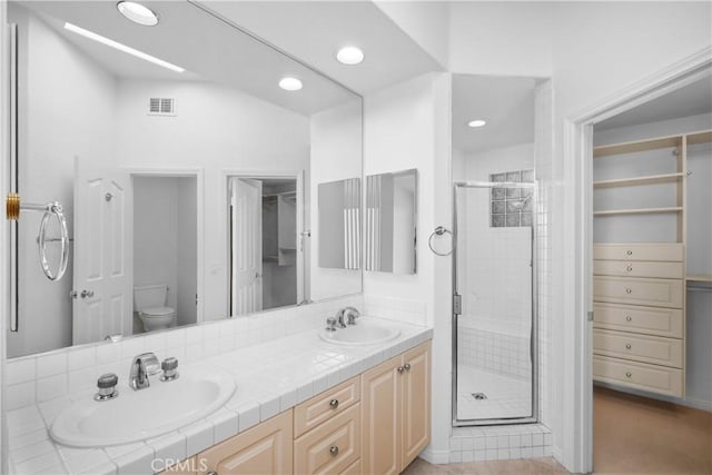 bathroom featuring visible vents, a stall shower, and a sink
