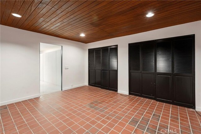 unfurnished bedroom featuring two closets, recessed lighting, light tile patterned floors, wooden ceiling, and baseboards