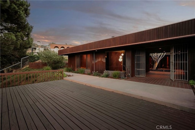 deck at dusk featuring a patio