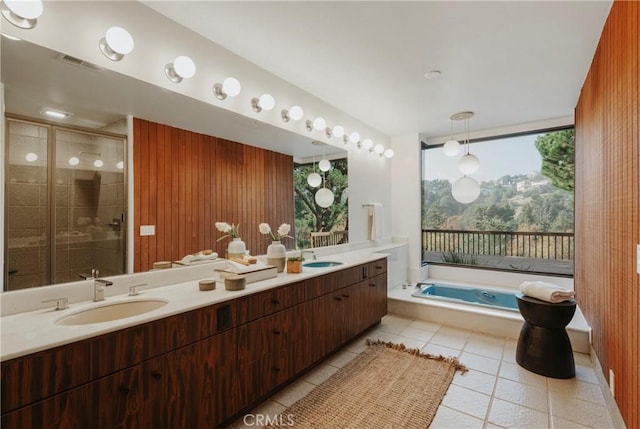 bathroom with visible vents, double vanity, a sink, a stall shower, and tile patterned flooring