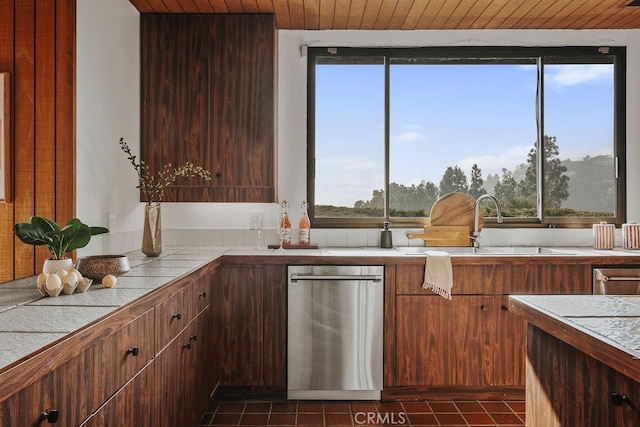 kitchen featuring a sink, tile counters, wooden ceiling, and dark tile patterned floors