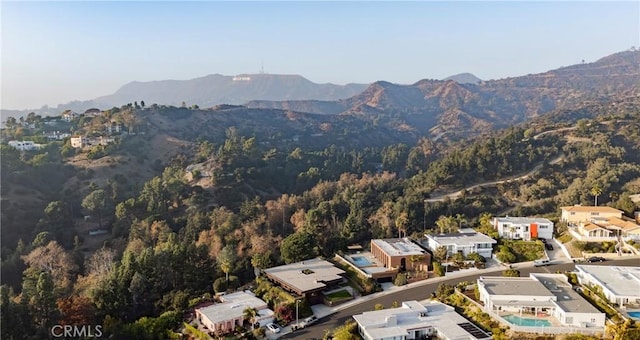 aerial view featuring a wooded view and a mountain view