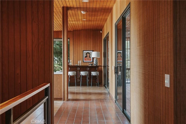 corridor featuring wood ceiling and wood walls