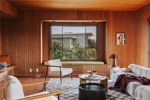 sitting room with wood finished floors, wood ceiling, and wood walls