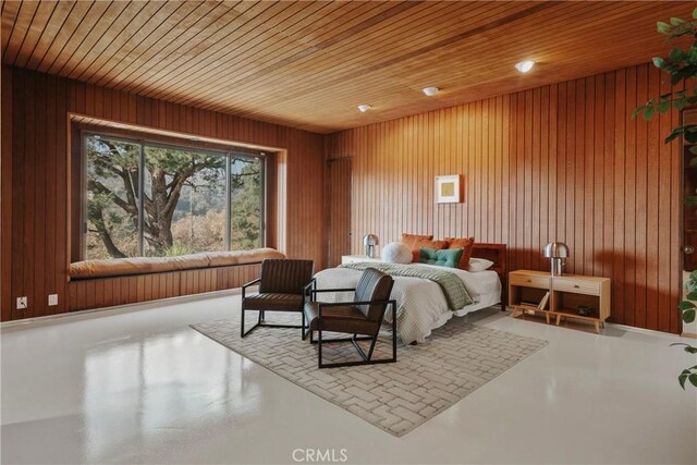 bedroom with concrete floors, wood walls, and wooden ceiling