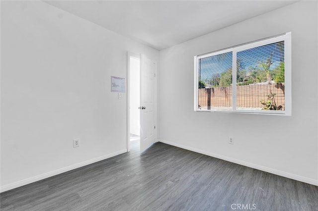 empty room featuring baseboards and wood finished floors