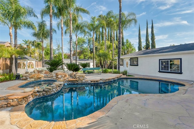 outdoor pool with a patio and an in ground hot tub