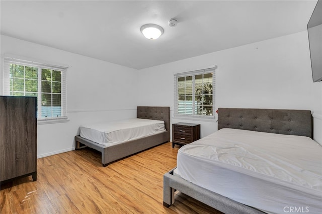 bedroom with light wood-style flooring and baseboards