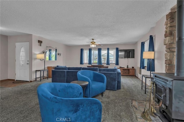 19506 Old Creek Rd, Hidden Valley Lake, CA 95467 - carpeted living area featuring baseboards, a textured ceiling, a wood stove, and a ceiling fan