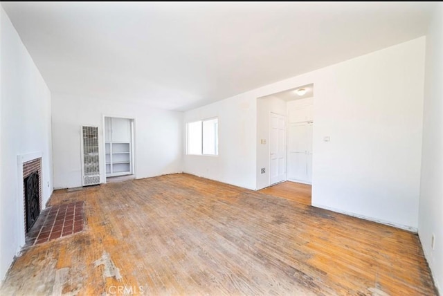13526 Dunton Dr, Whittier, CA 90605 - unfurnished living room with a heating unit, a fireplace, and wood finished floors