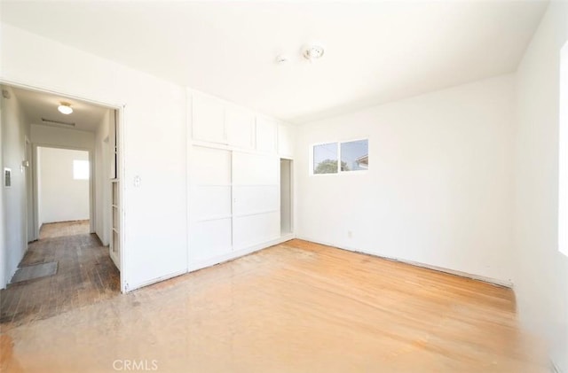 13526 Dunton Dr, Whittier, CA 90605 - unfurnished bedroom featuring multiple windows, light wood finished floors, and a closet