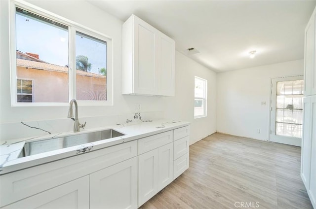 13526 Dunton Dr, Whittier, CA 90605 - kitchen with white cabinetry, light stone counters, and light wood-style flooring