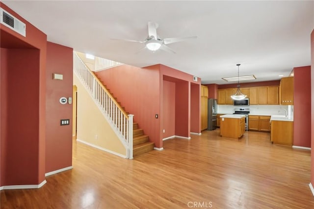 42042 Chestnut Dr, Temecula, CA 92591 - unfurnished living room featuring visible vents, stairway, ceiling fan, light wood-style flooring, and baseboards