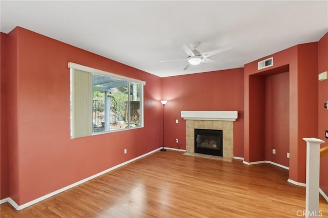 42042 Chestnut Dr, Temecula, CA 92591 - unfurnished living room with a tile fireplace, a ceiling fan, visible vents, and wood finished floors