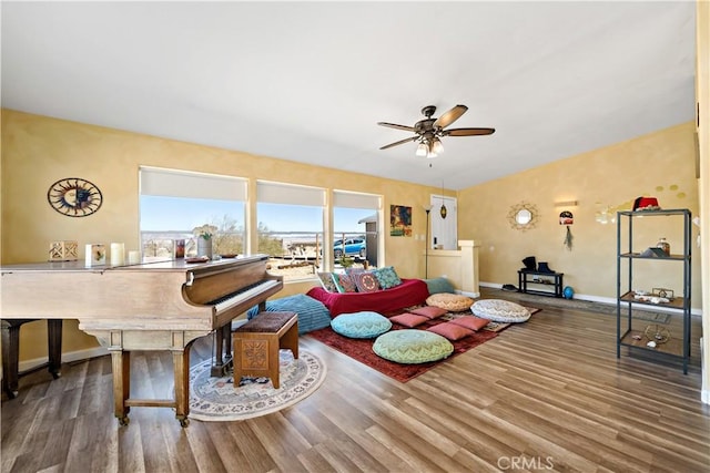 living area with baseboards, ceiling fan, and wood finished floors