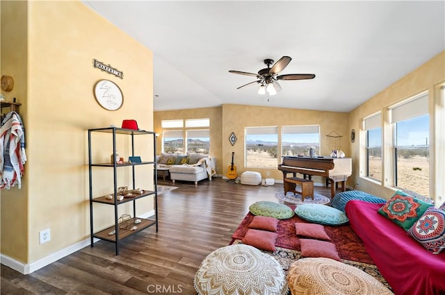 living room featuring wood finished floors, baseboards, vaulted ceiling, and ceiling fan