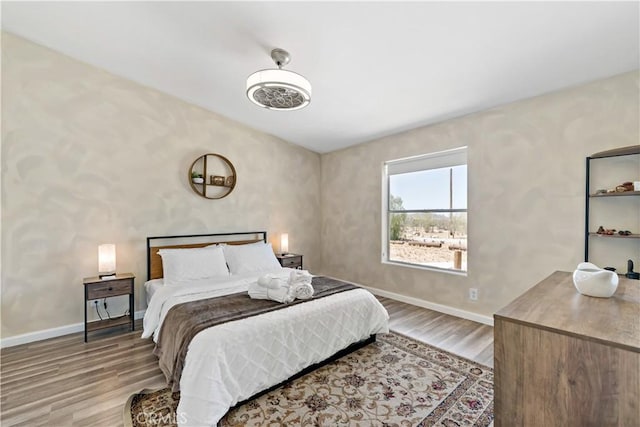 bedroom with baseboards and wood finished floors