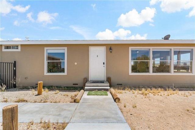 view of front facade with fence and crawl space