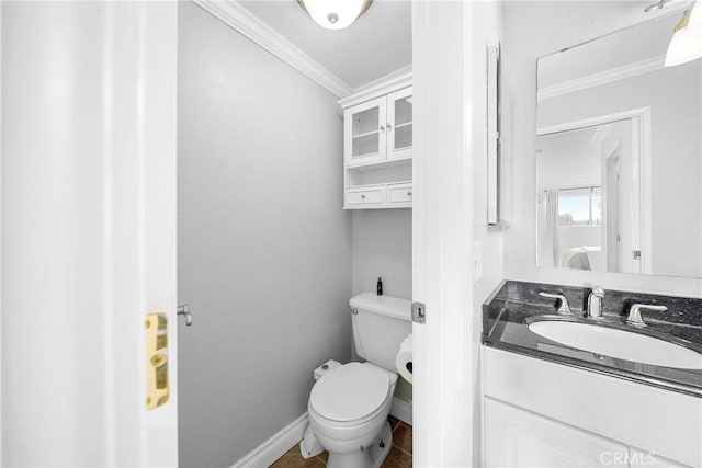 bathroom with baseboards, ornamental molding, toilet, and vanity