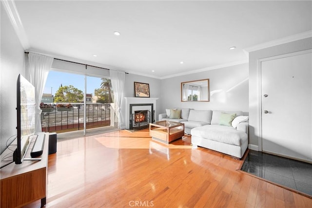 living area featuring a fireplace with flush hearth, recessed lighting, crown molding, and wood finished floors